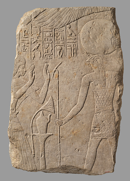 Pay lève les mains devant Rê-Horakhty, représenté avec une tête de faucon et un disque solaire, sur un fragment de stèle en calcaire de Saqqara. Le Met date l’objet d’environ 1328–1318 avant notre ère ; inventaire 04.2.527